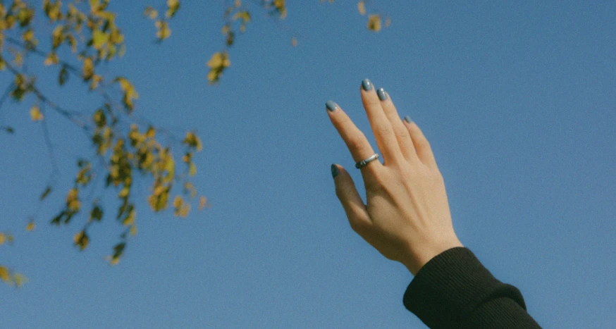 a person holding their hand up to the sky