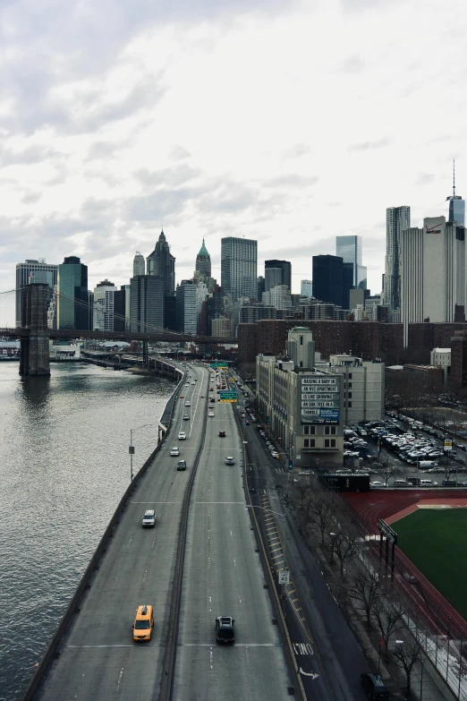 a city by the water has cars driving