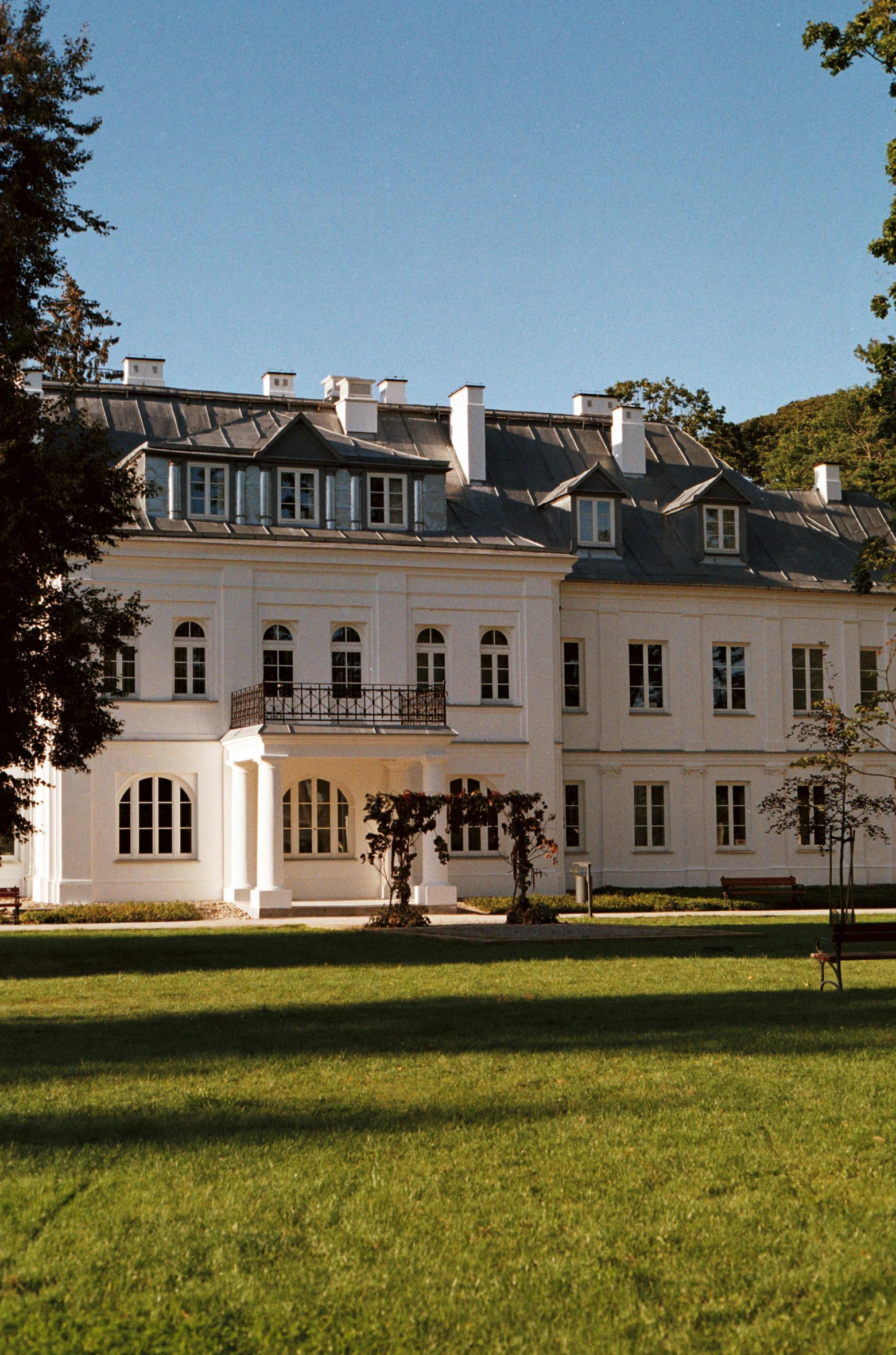 a large white house with some trees near by