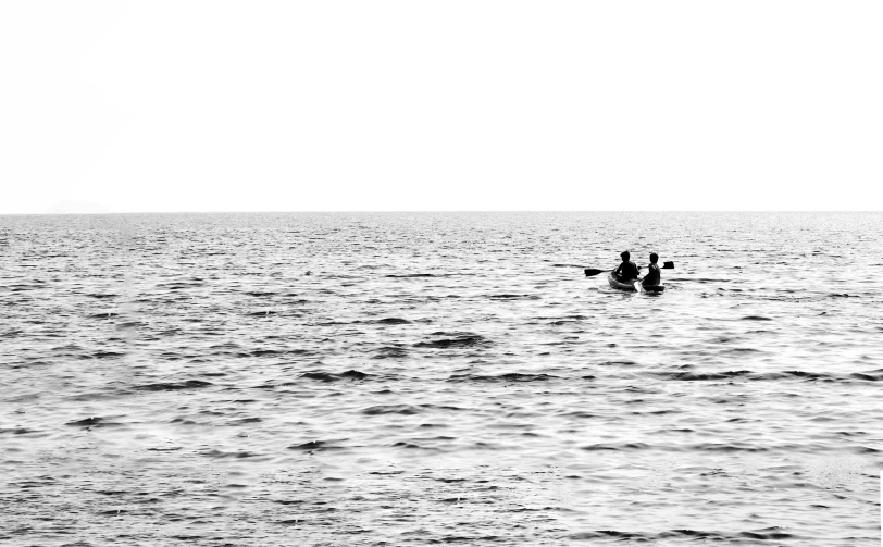 two people are paddling a boat in calm waters