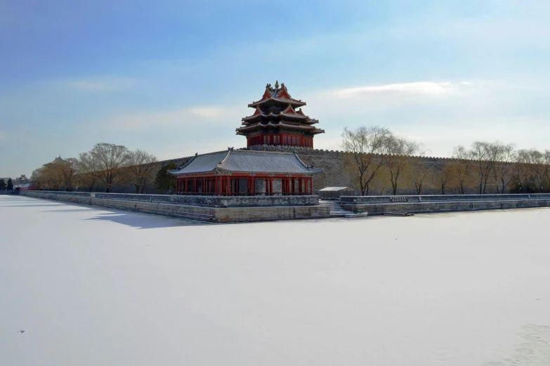 snow covered field and building with tall tower in background