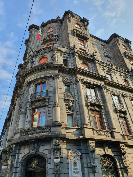 a tall gray building with two large windows