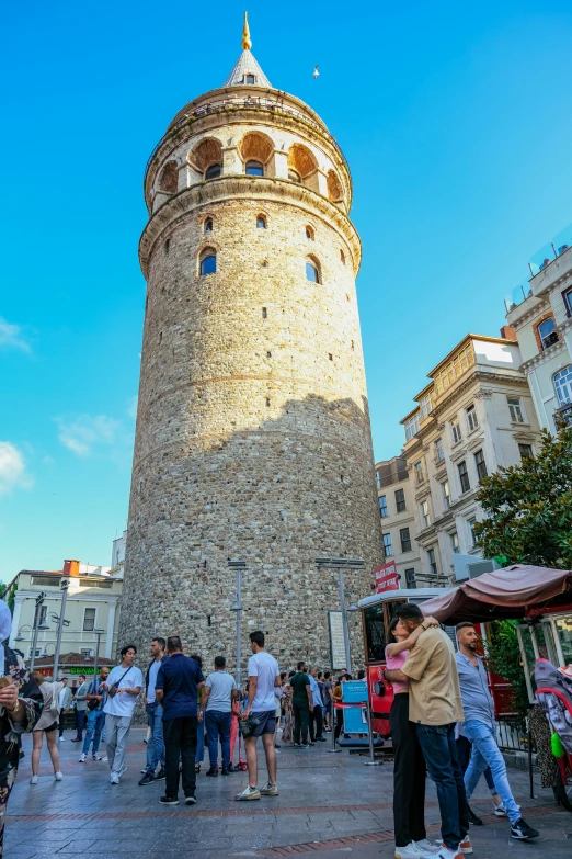 the people in front of the tower are milling about