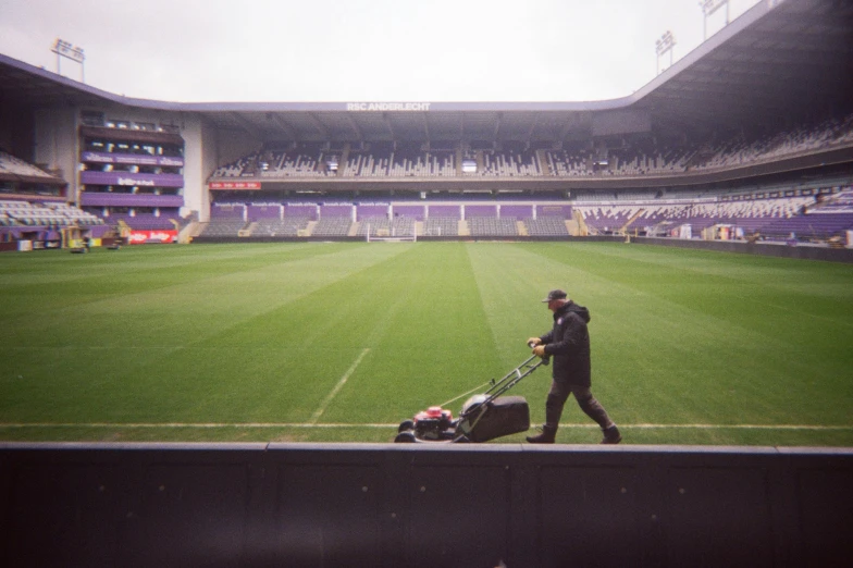 a man pulls a h trolley in an empty stadium