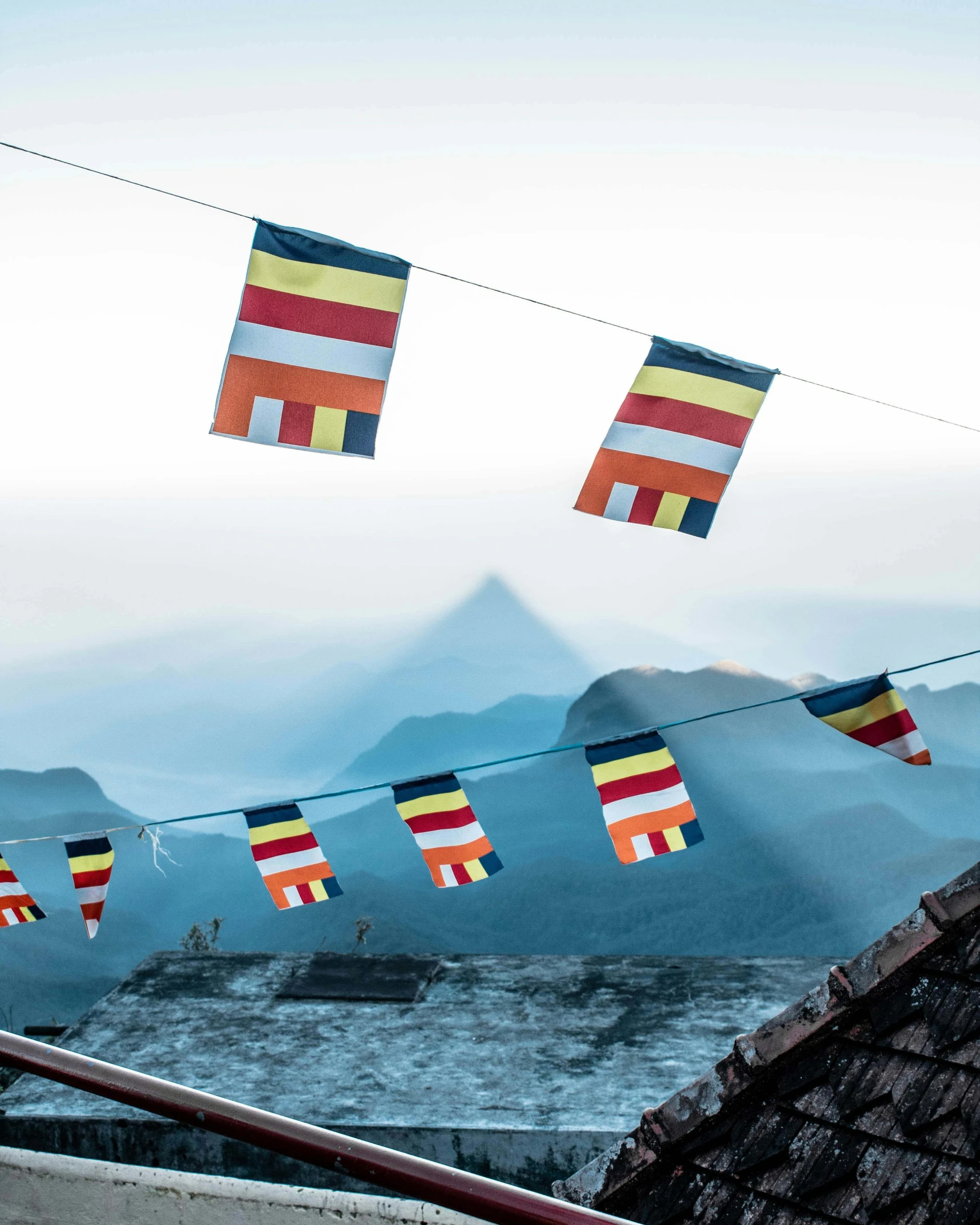 colorful banners hung on the clothes line near some mountains