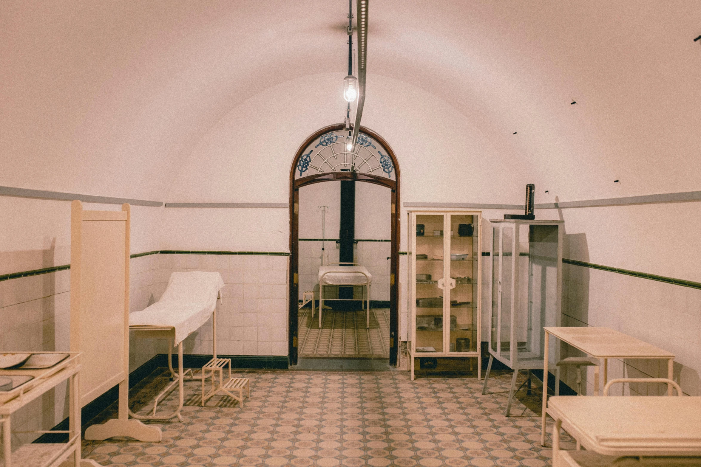 a hospital room filled with lots of beds and tables