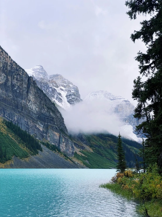 snow capped mountains on the top of a large lake