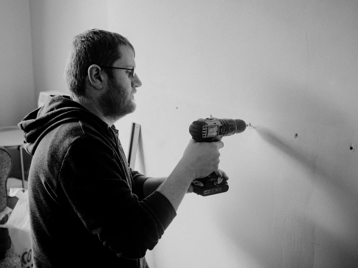 man holding a sprayer in his hand while brushing his teeth