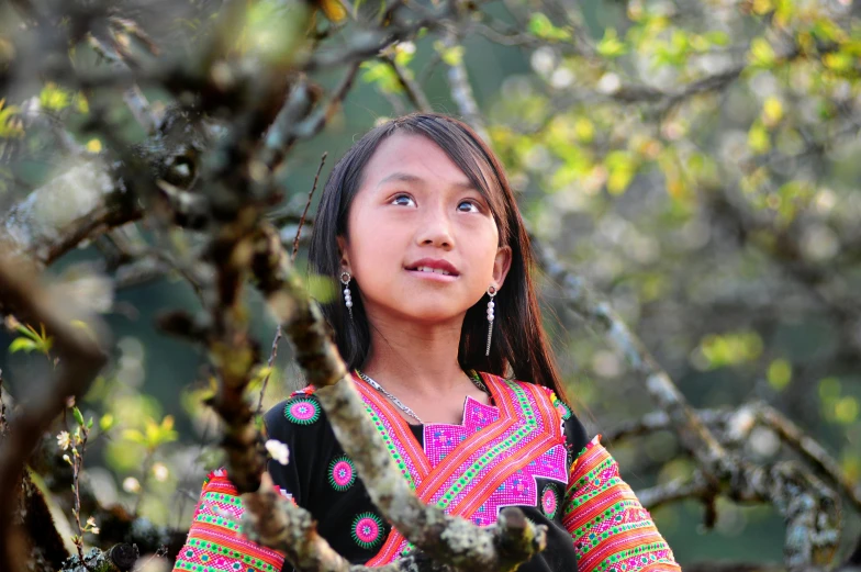 a little girl looking up in the trees