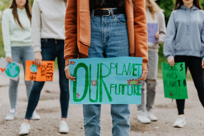 people standing in line holding signs and signs that say planet future