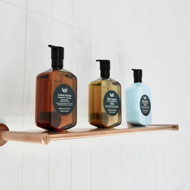 three bottles of bath soap on a shelf