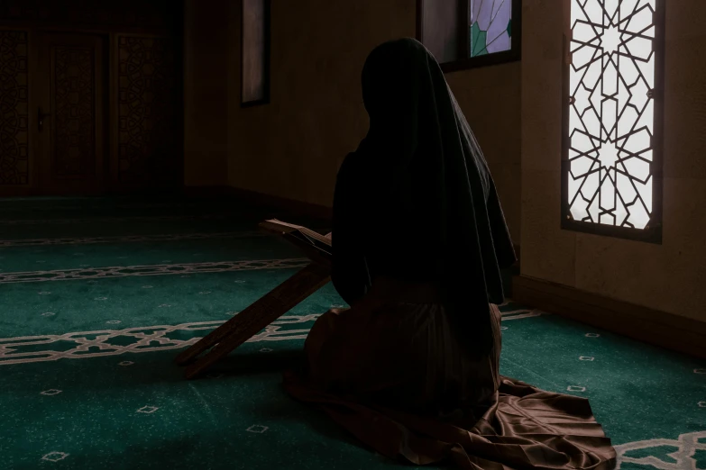 a woman sitting in the middle of a room with a wooden floor