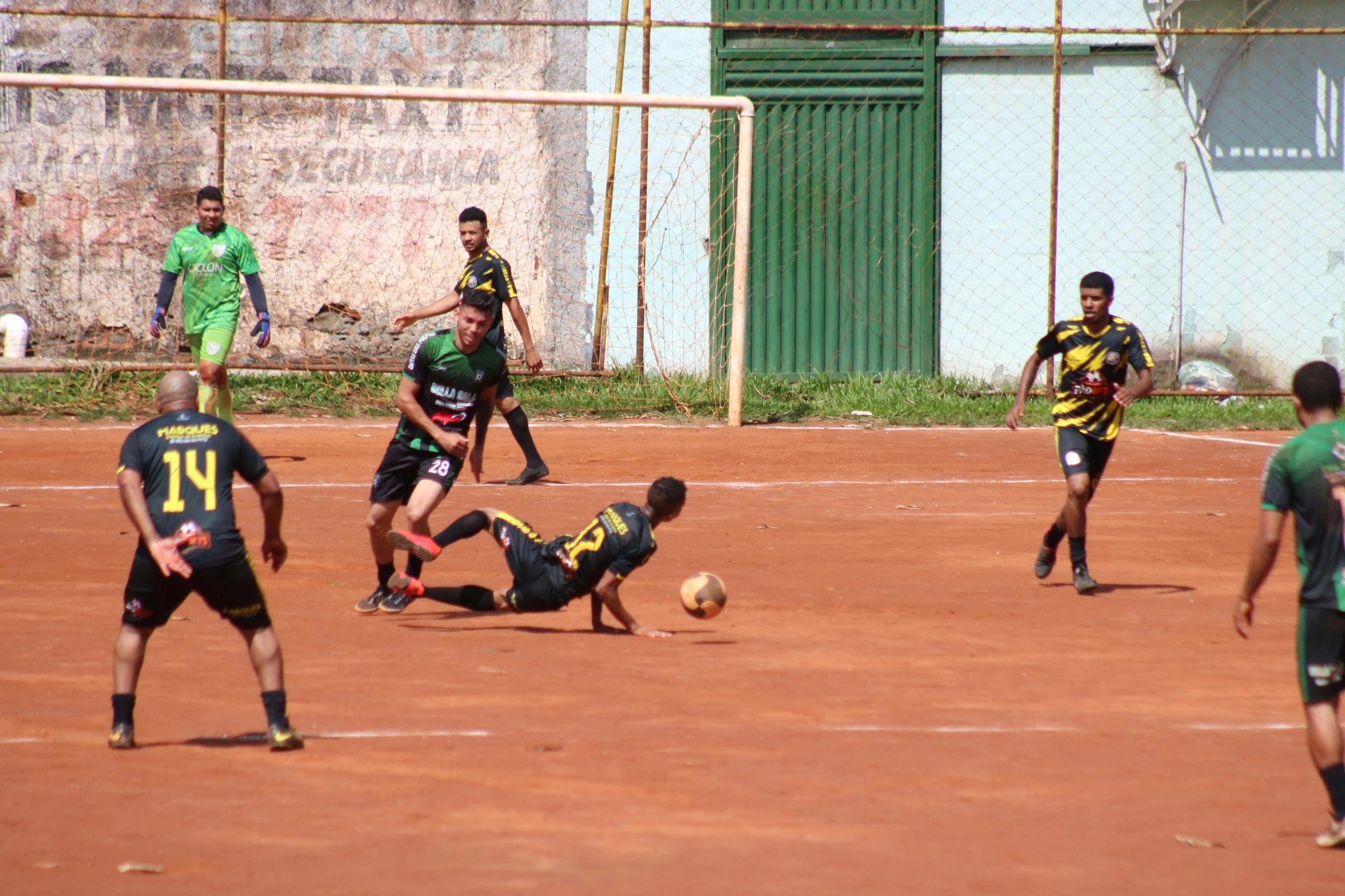 people are on a dirt field playing soccer