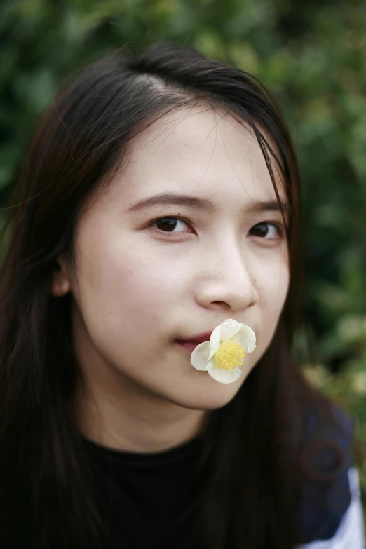 an oriental girl with a flower in her mouth