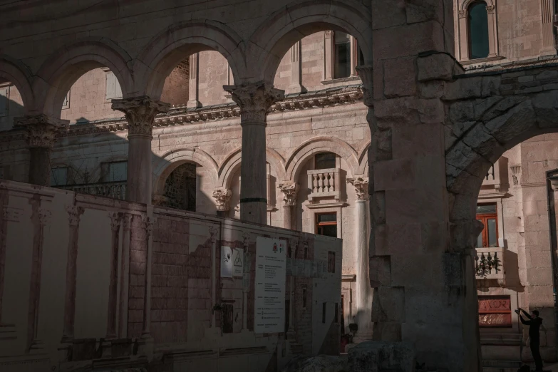 the shadow of an old building shows through several arches