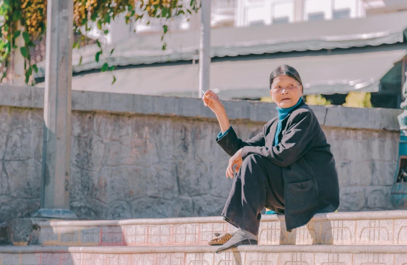 a woman sitting on a stone step holding a kite