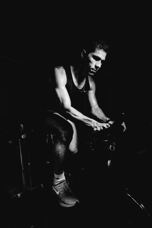 a man sitting on a stool in the dark