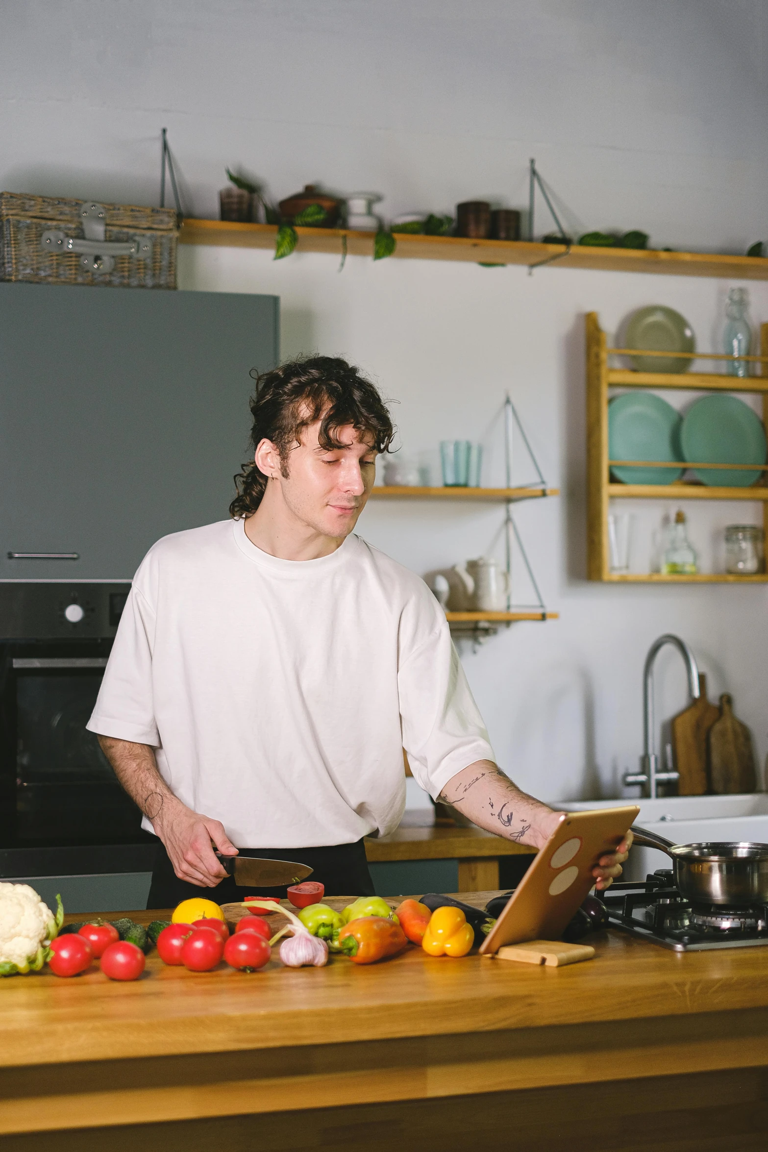 a man standing over a  board with vegetables on it