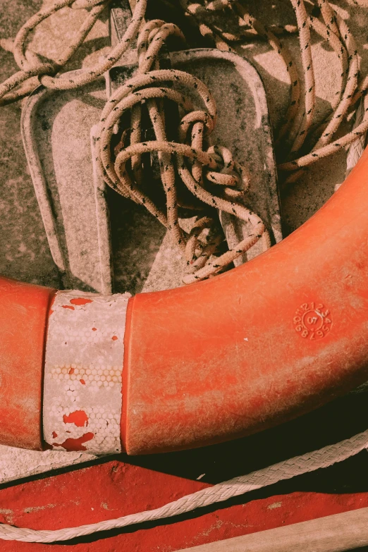 the orange rubber boot is tied up on the sand