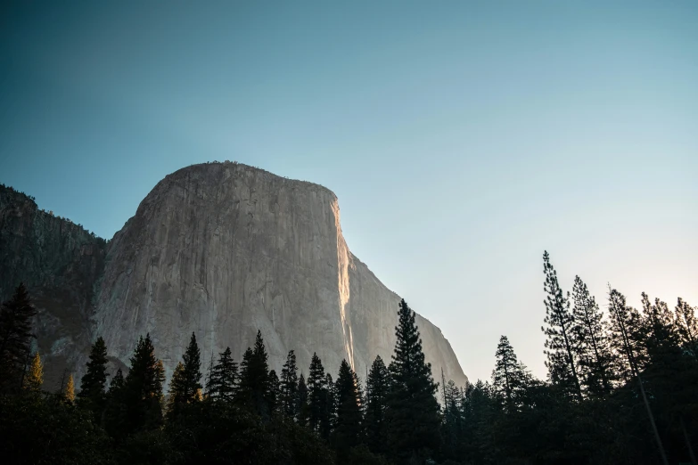 a mountain with trees and the sky behind it