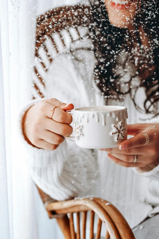 woman holding coffee cup while covered in snow