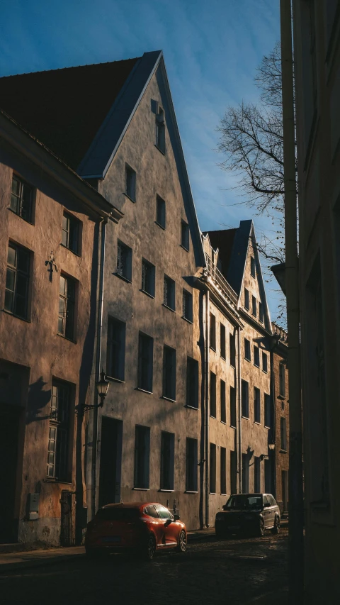 cars parked along a side street near a large building