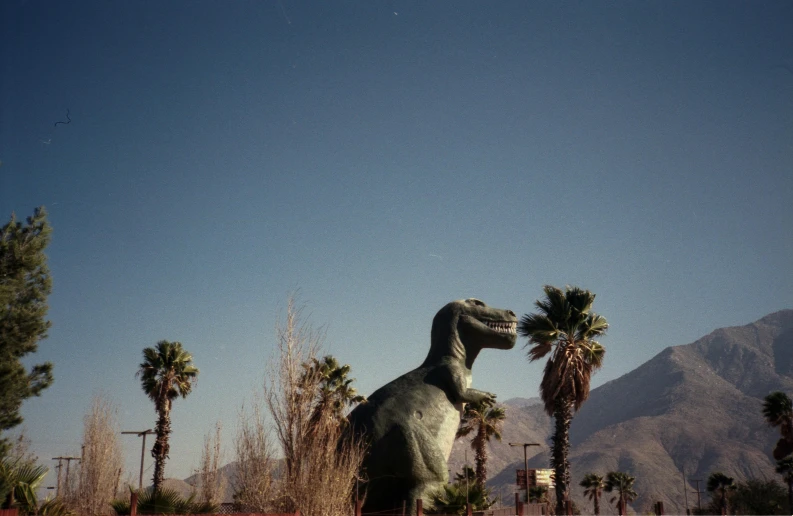 a statue of a dinosaur in the desert