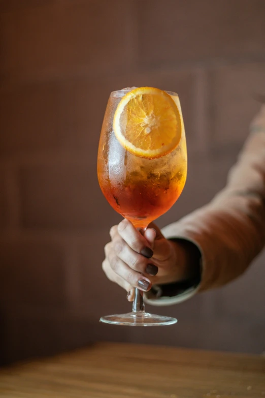 an person holding up a glass with some fruit inside it