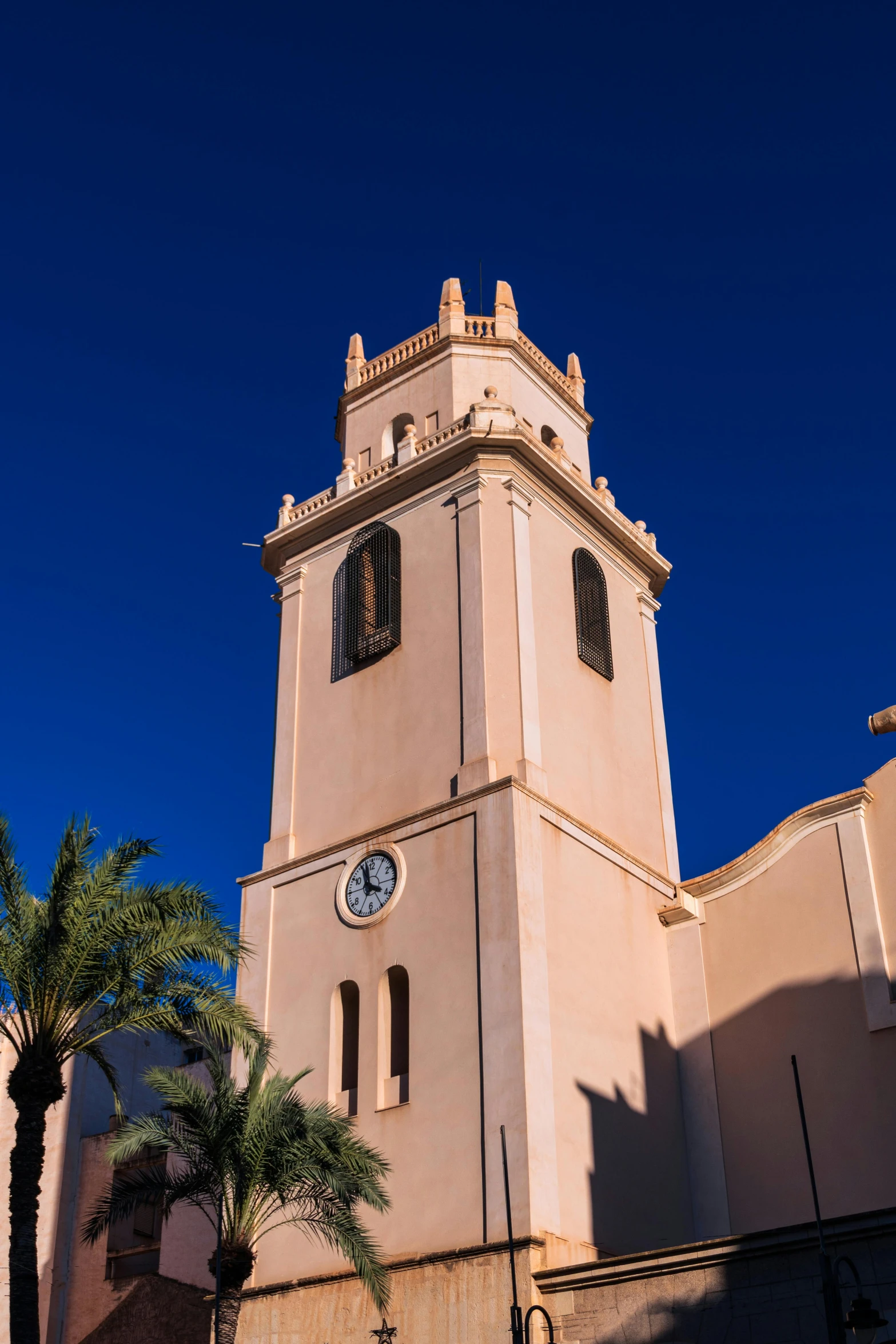 a clock tower with palm trees in front of it