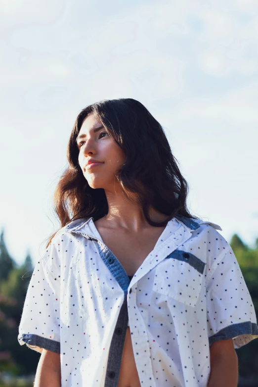 the woman with the white polka dot shirt and blue suspenders looks to the side