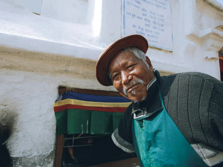 a smiling man standing next to an entrance in a building