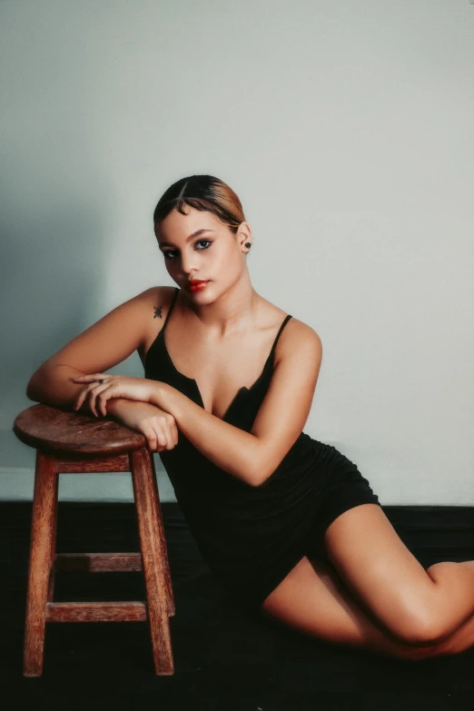 a woman in a bathing suit sitting on a stool