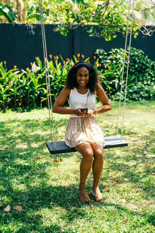 a woman swinging in the back yard with another female