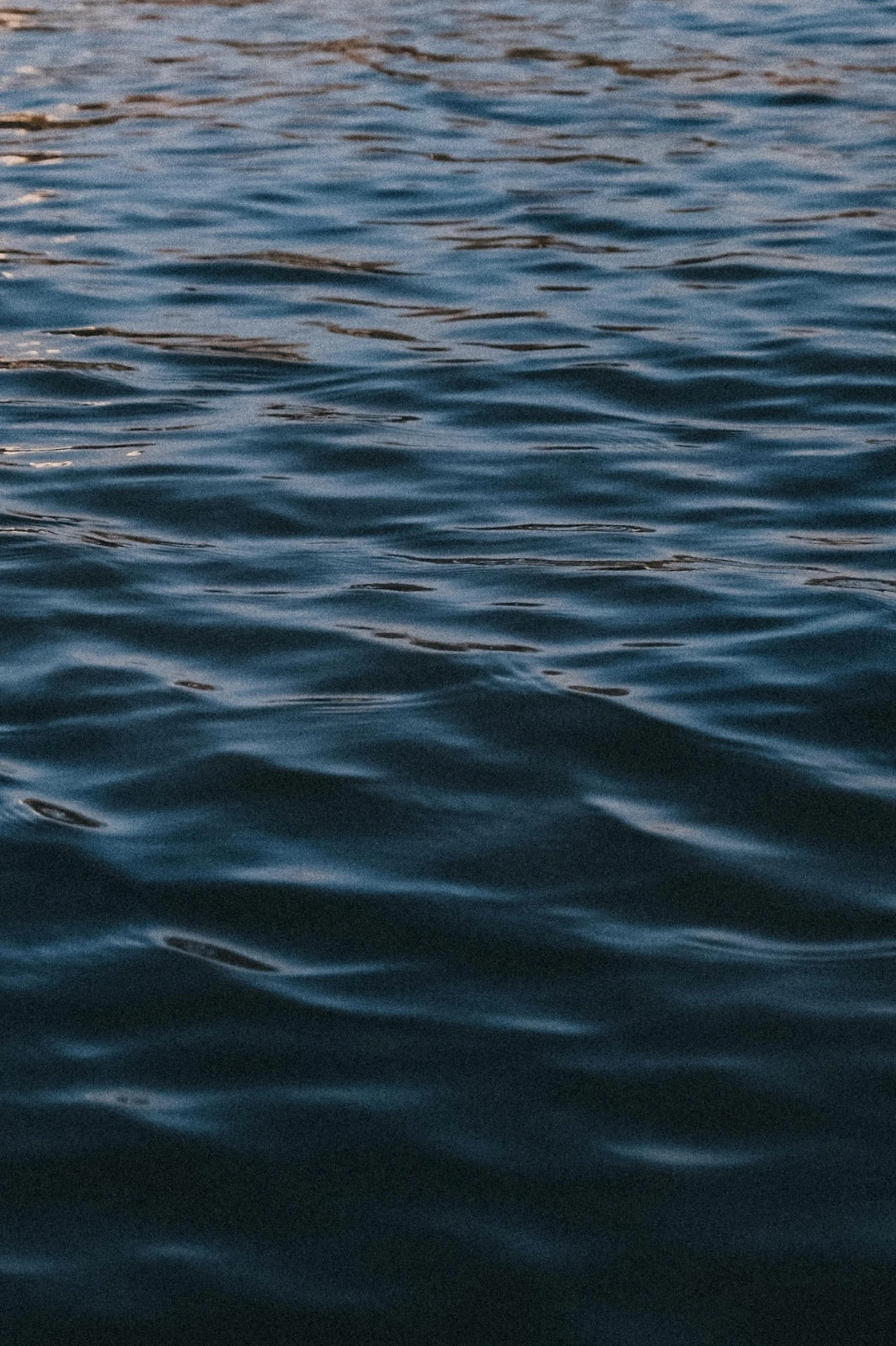 dark water waves with white clouds are the backdrop