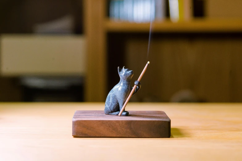 a small cat figurine is standing on the wooden table