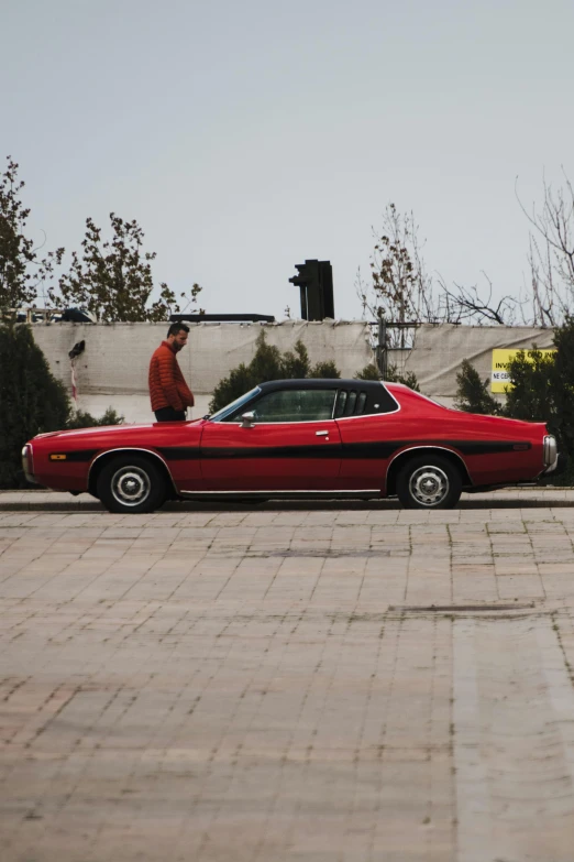 a red classic car parked on the street