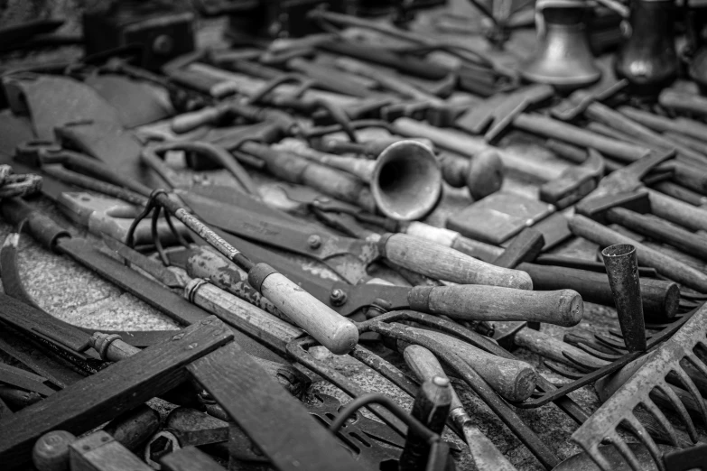 a black and white pograph of a pile of old wood working tools