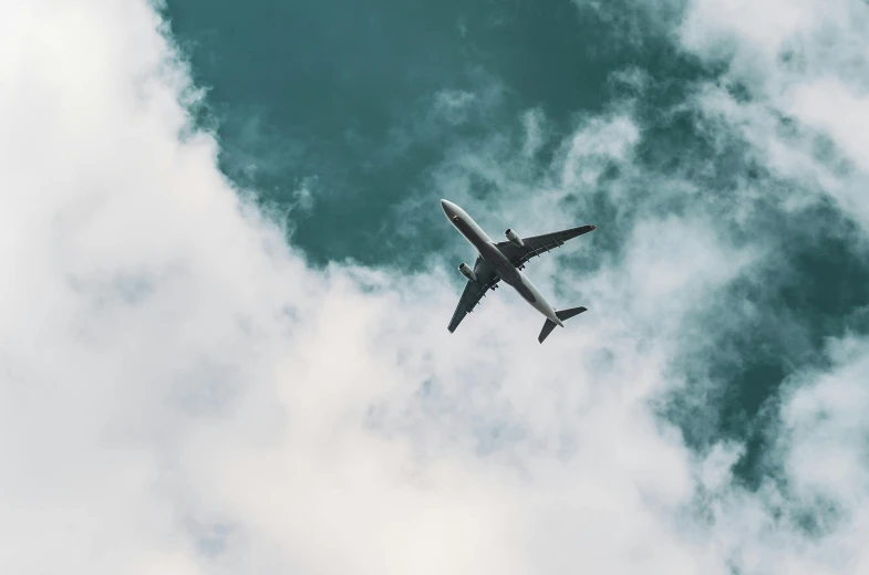 an airplane flying in the sky on a cloudy day