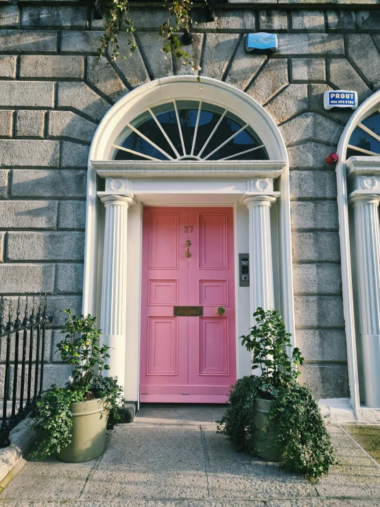 pink door on stone building with arched window