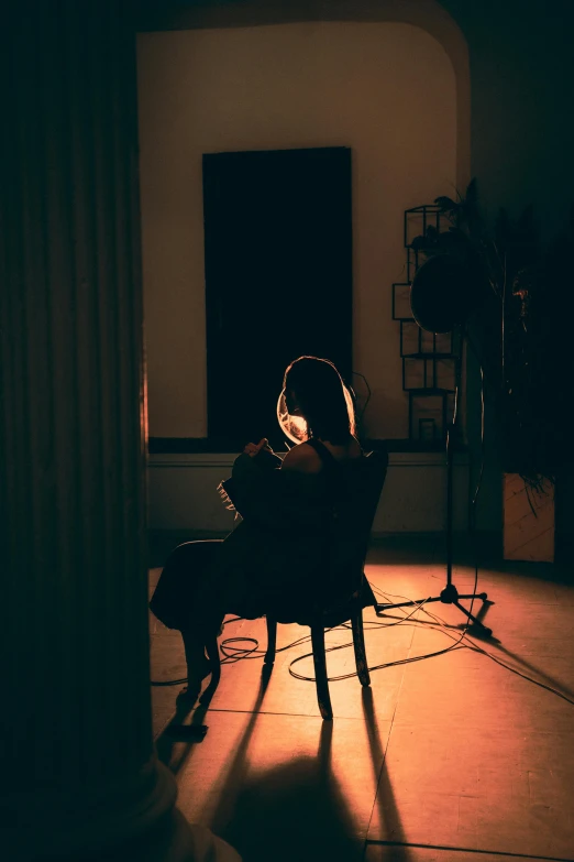 a dark room with a chair, lights, and a microphone