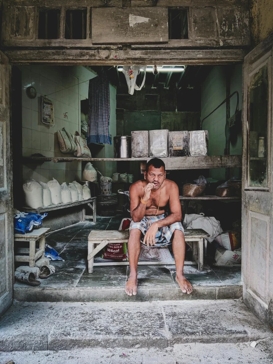 a man sits in a garage with his dog on the floor