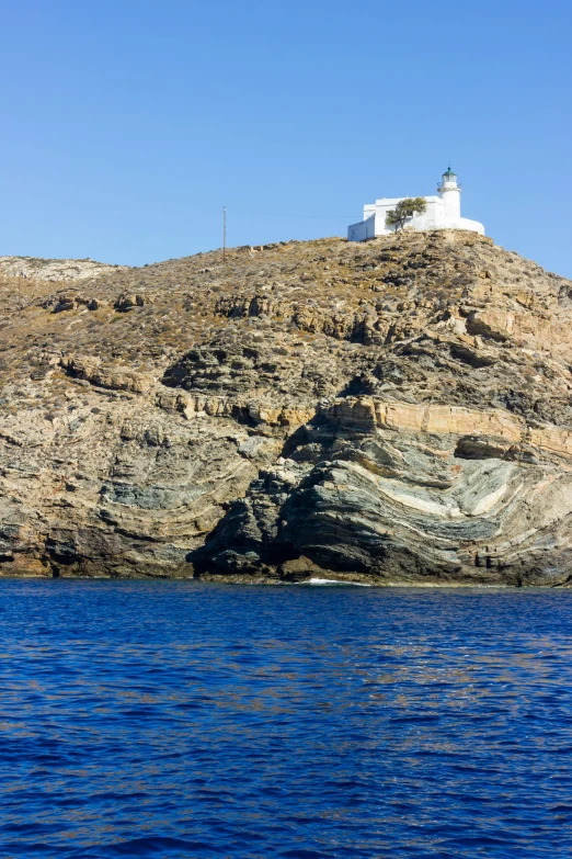 a boat is floating on the water near a hill