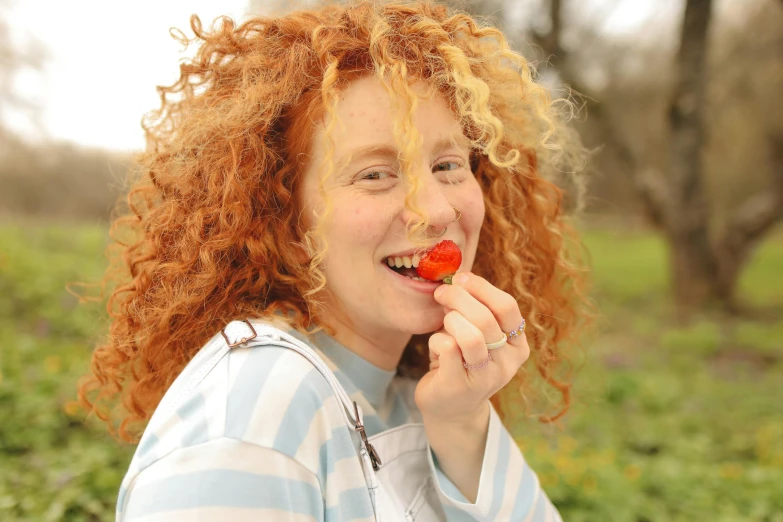 an image of a woman eating a strawberry