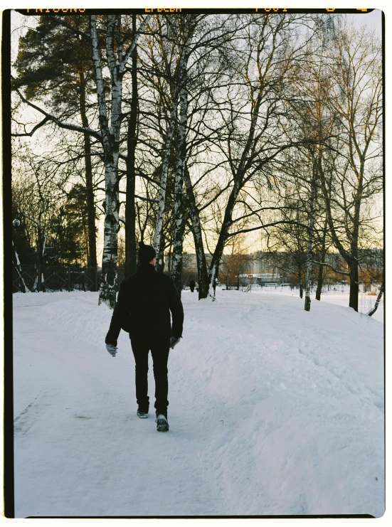 a man with a snowboard is walking through the snow