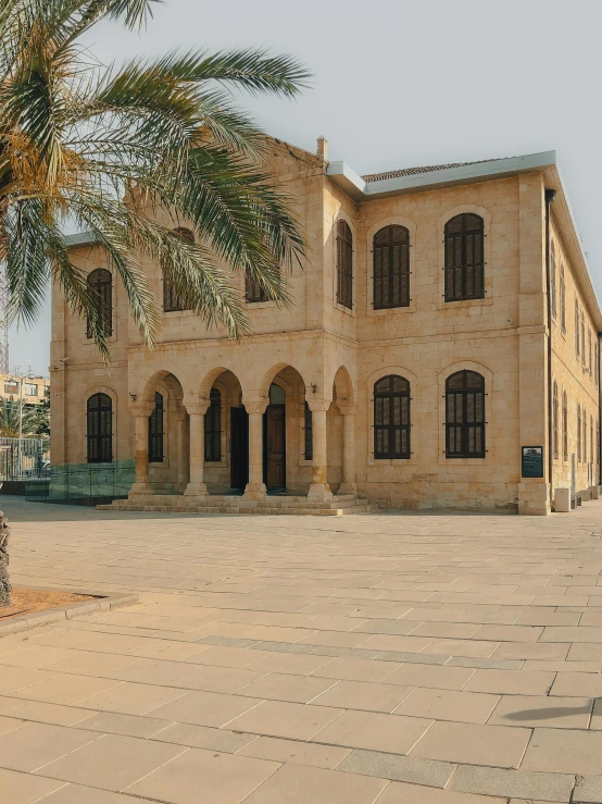 a large brown building sitting next to a palm tree