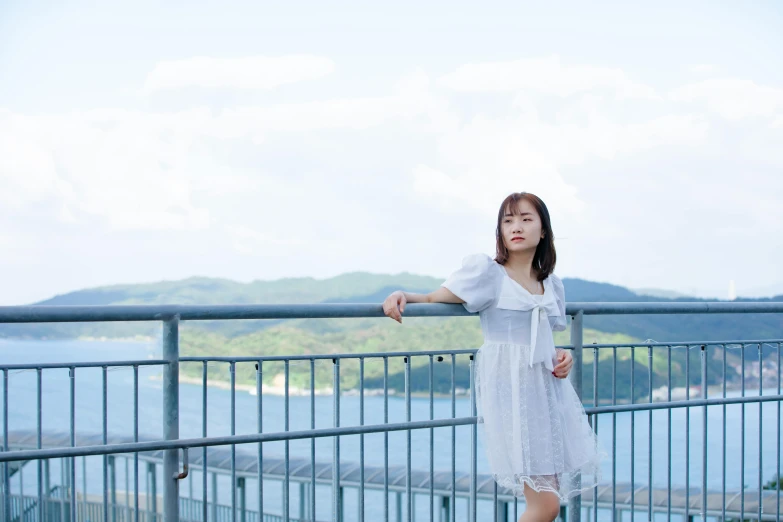 a girl posing on a bridge with water behind her