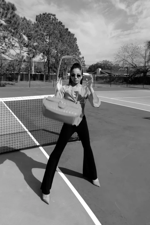 woman standing on tennis court holding up a racket