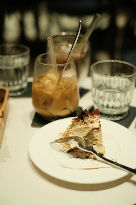 a close up of a slice of cake on a plate with glasses