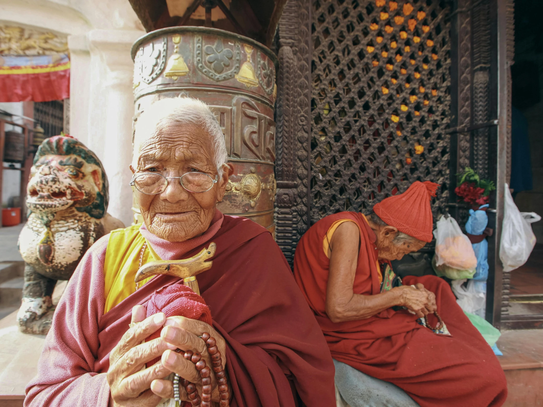 an old man sits outside with two other men