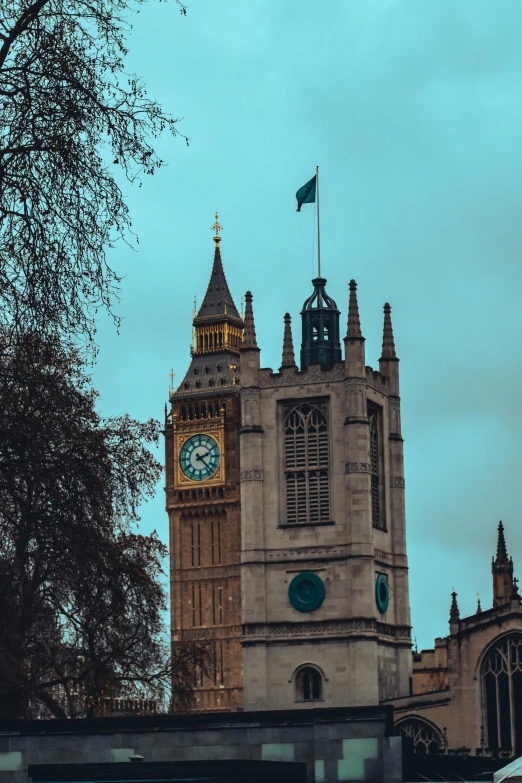 an old building with a tower, clock and flag on it